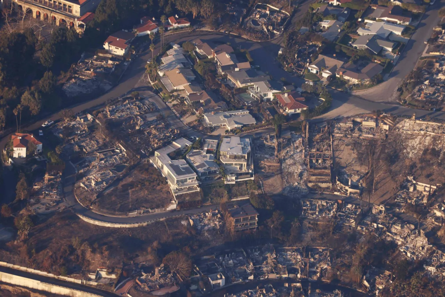 صورة جوية لمنازل ومحلات تجارية تحولت إلى أنقاض مشتعلة بسبب حريق في منطقتَي باسيفيك وباليساديس في لوس أنجليس بولاية كاليفورنيا (أ.ف.ب)