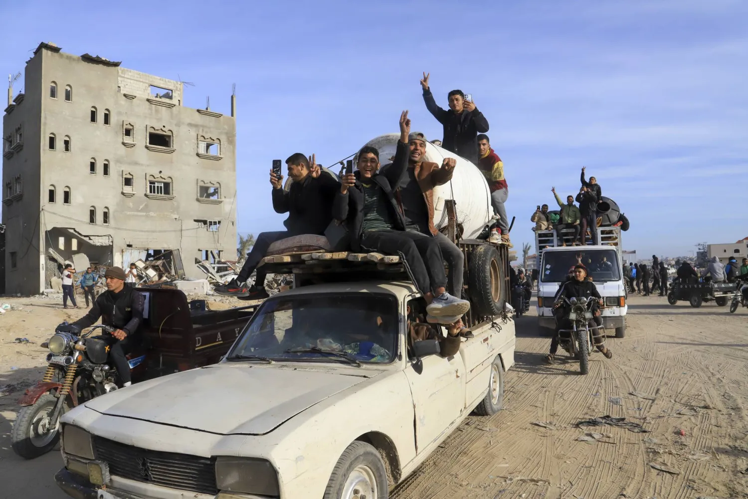 نازحون فلسطينيون عائدون بسياراتهم إلى منازلهم في رفح (أ.ب)