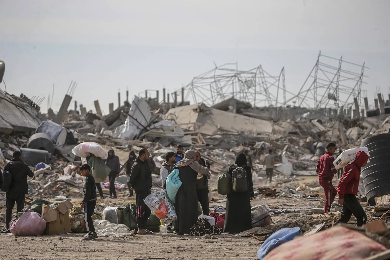 طوابير من الفلسطينيين يحملون أمتعتهم في طريق عودتهم لمنازلهم بجنوب قطاع غزة (إ.ب.أ)