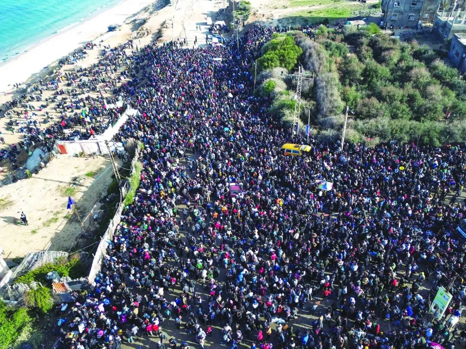 
حشود فلسطينية تنتظر العودة إلى شمال غزة في مخيم النصيرات وسط القطاع أمس (إ.ب.أ)