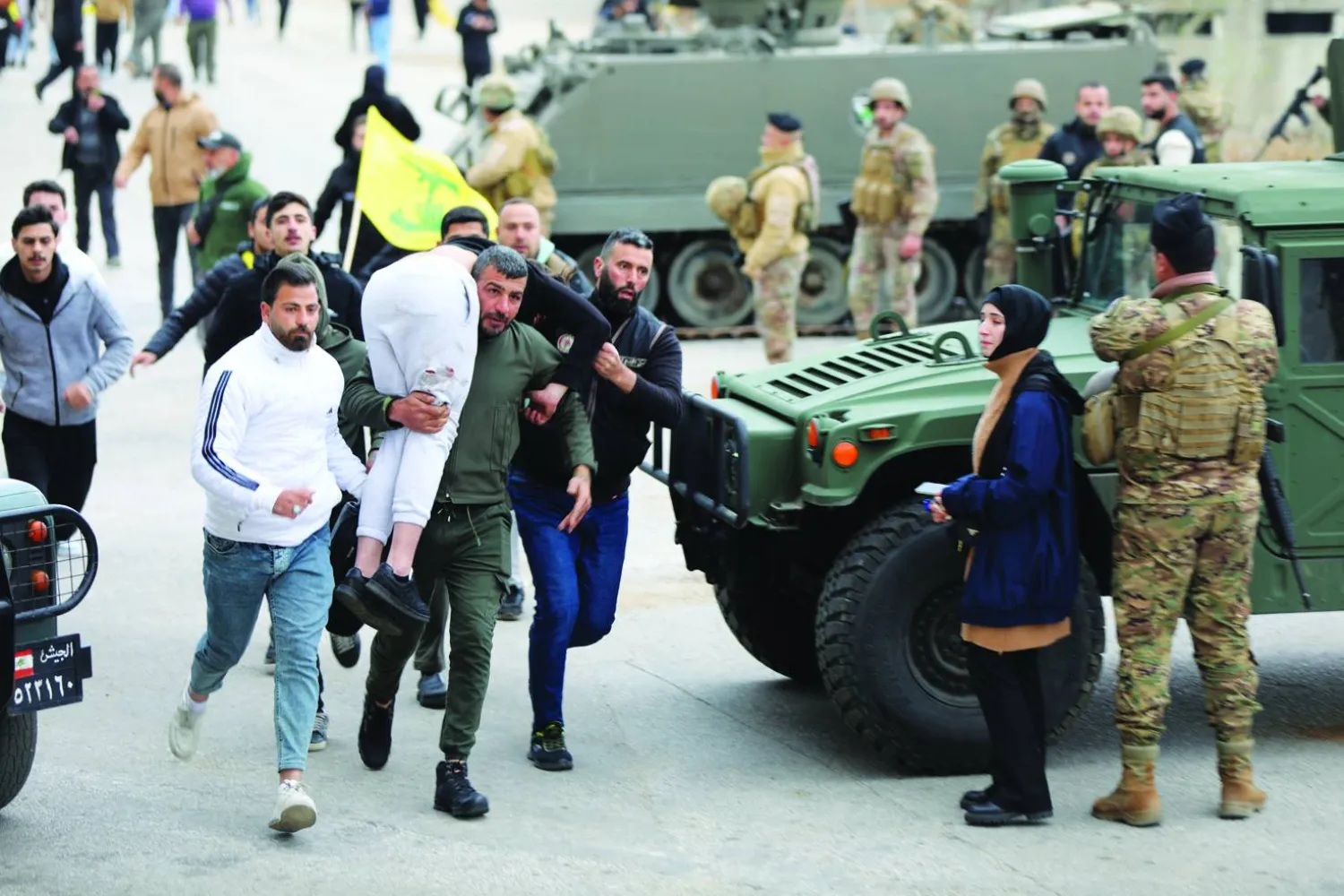 
رجل يحمل شخصاً أصيب برصاص الجيش الإسرائيلي قرب بلدة كفركلا جنوب لبنان (رويترز)