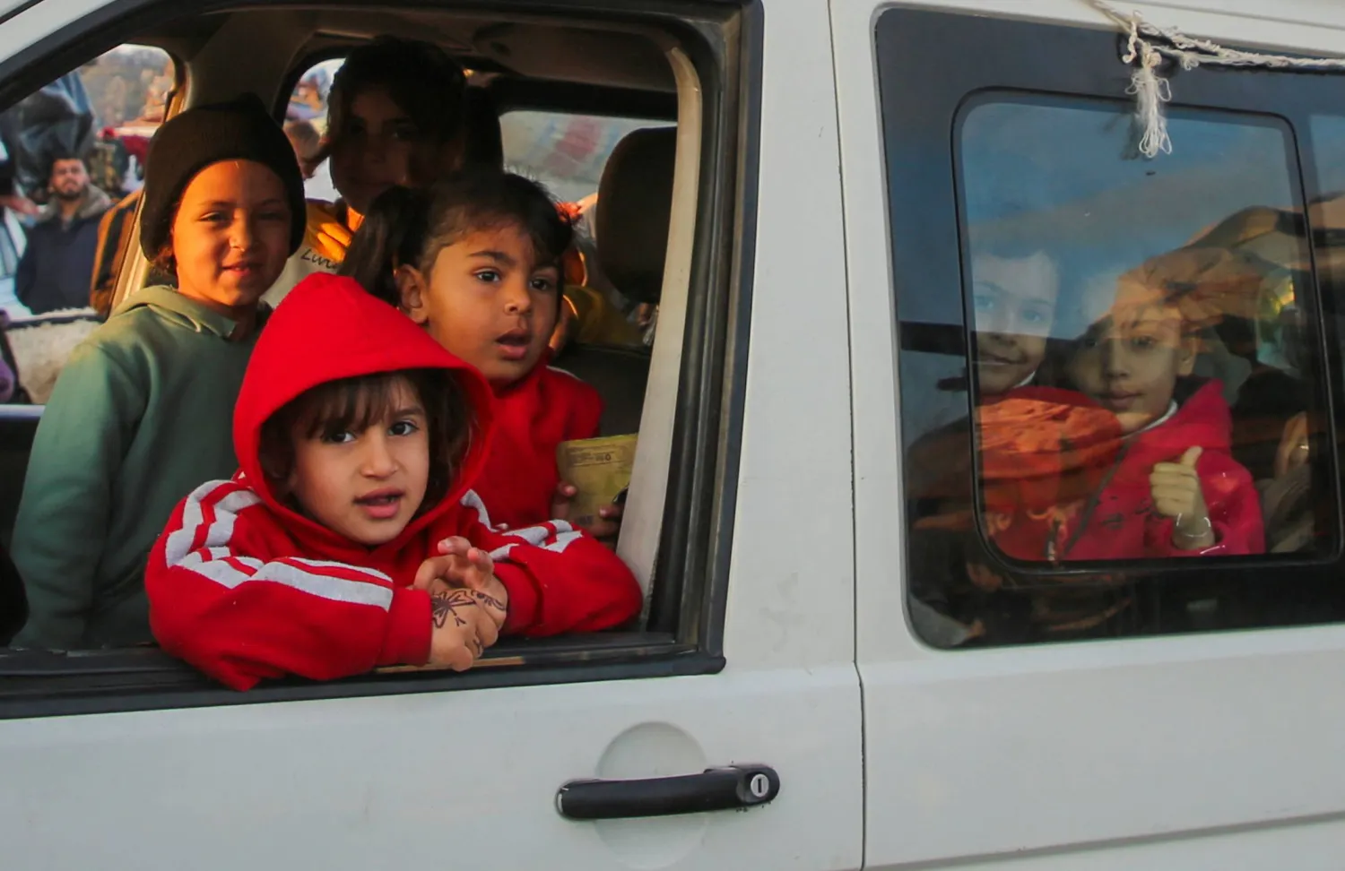 أطفال غزة في حافلة ينتظرون العبور إلى شمال قطاع غزة (رويترز)