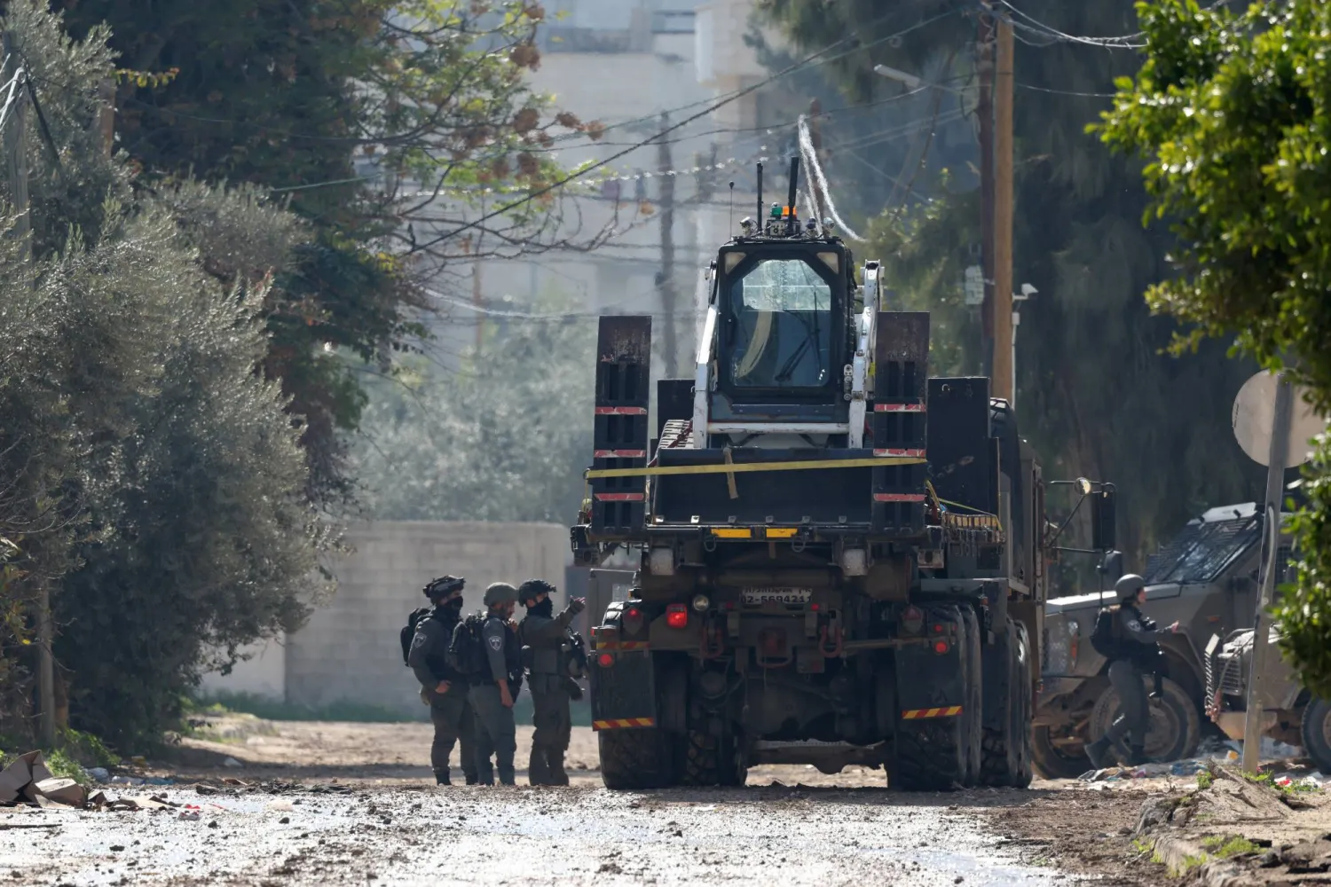 جنود إسرائيليون مع مركباتهم على طريق في اليوم السابع من العملية العسكرية الإسرائيلية في جنين بالضفة الغربية يوم 27 يناير 2025 (إ.ب.أ) 