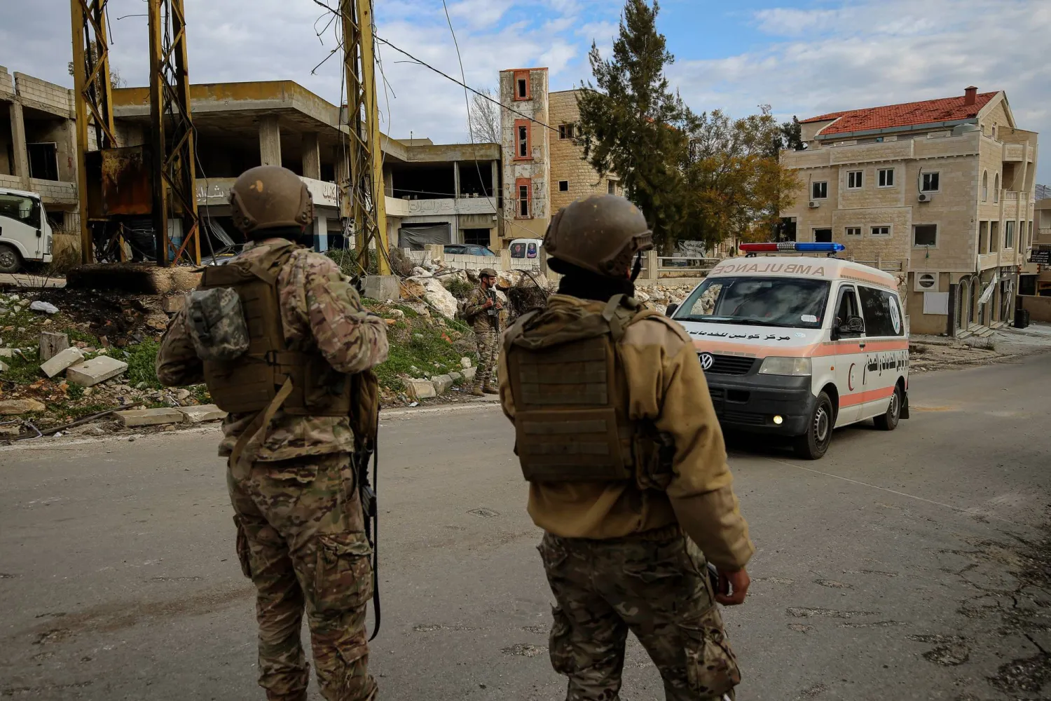 جنود لبنانيون يفتحون الطريق أمام سيارة إسعاف تحمل جريحاً لبنانياً أصيب برصاص الجيش الإسرائيلي أثناء محاولته دخول قريته عيترون في جنوب لبنان (د.ب.أ)