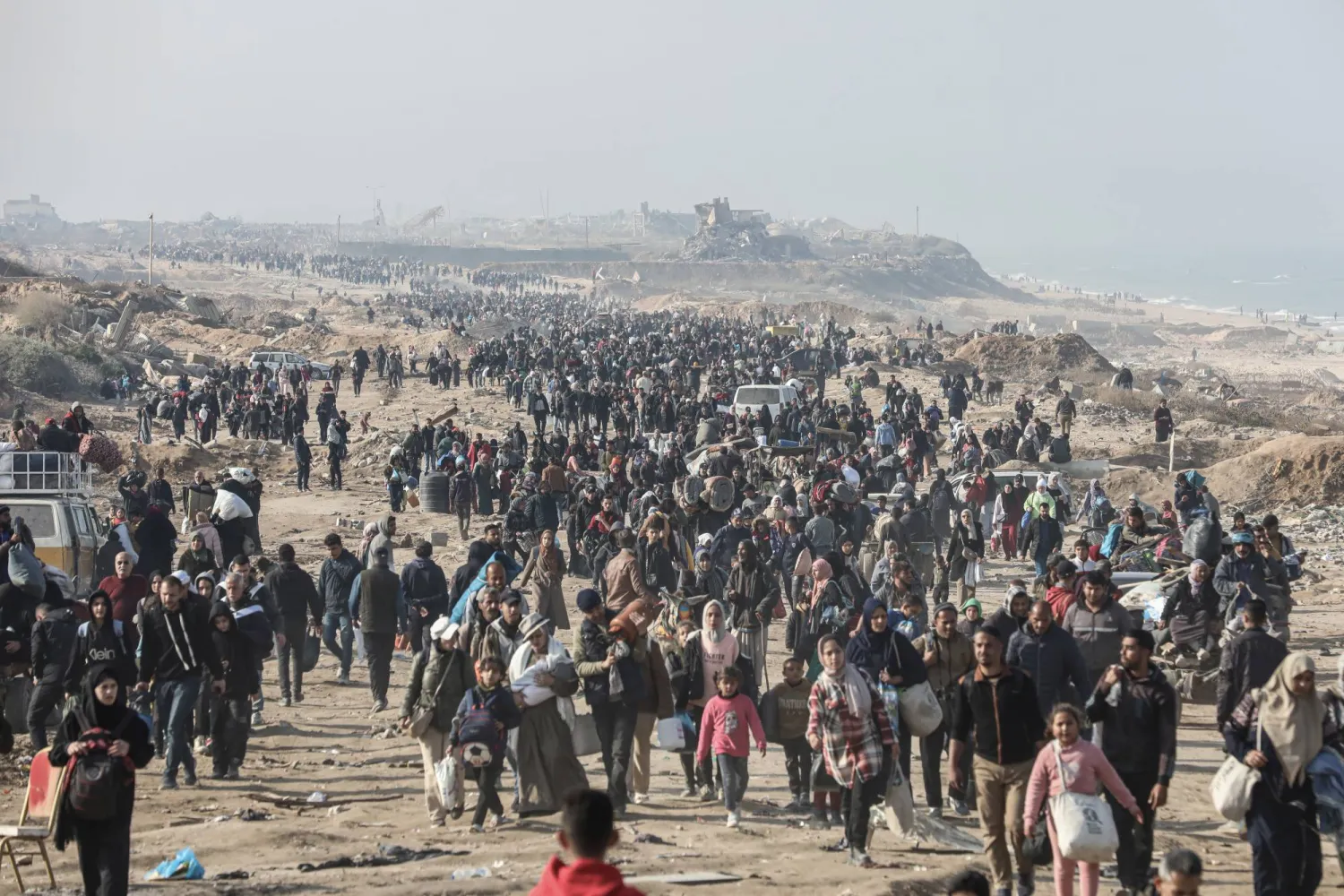 نازحون فلسطينيون يحملون أمتعتهم في طريقهم للعودة إلى منازلهم شمال قطاع غزة (د.ب.أ)