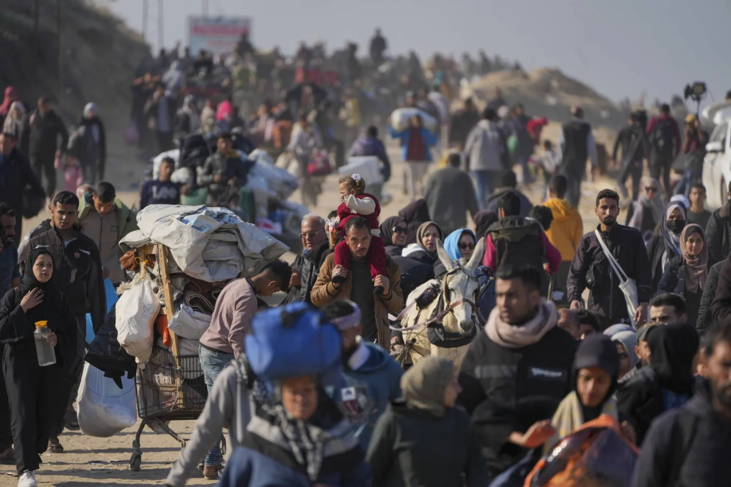 فلسطينيون نازحون يسيرون على طريق في وسط غزة للعودة إلى منازلهم في شمال القطاع (أ.ب)