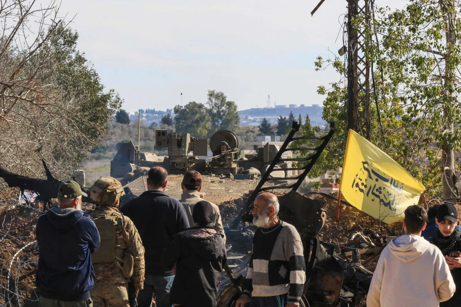 مواطنون إلى جانب جنود لبنانيين يحاولون العبور إلى بلدة يارون (أ.ف.ب)