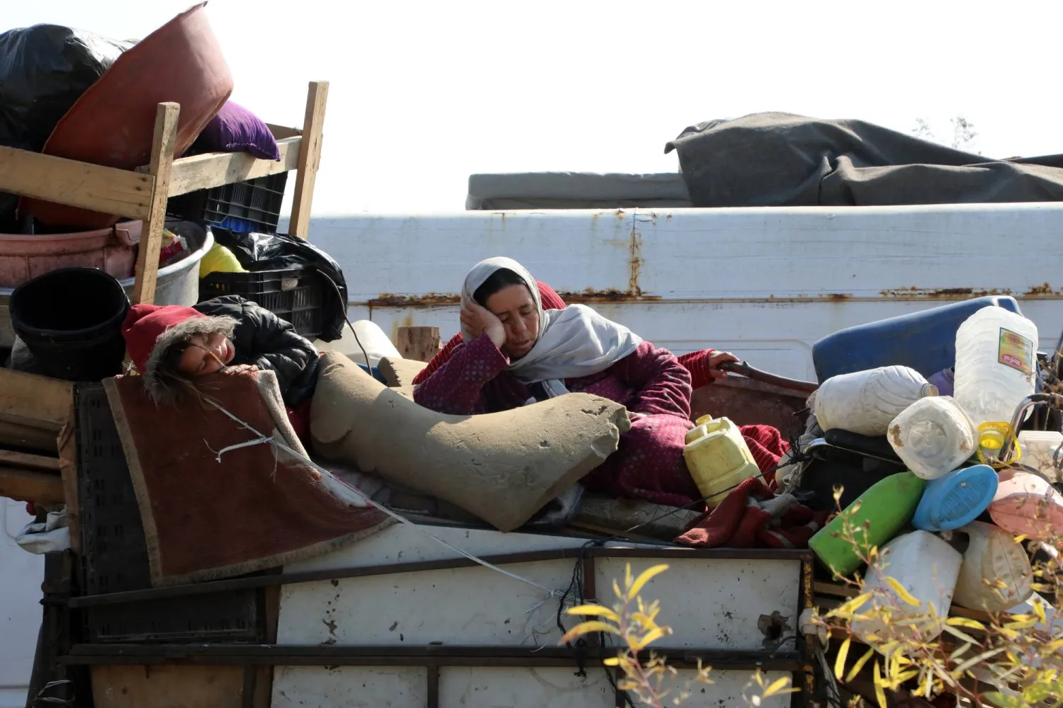 امرأة تنام على بعض الأمتعة في طريقها من المناطق الجنوبية إلى شمال غزة عبر طريق صلاح الدين (د.ب.أ)
