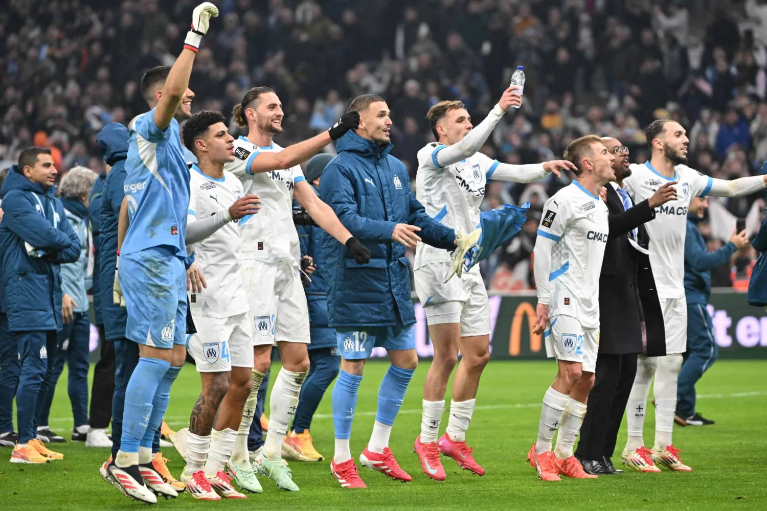 Marseille's players celebrate after winning the French L1 football match between Olympique de Marseille (OM) and Olympique Lyonnais (OL) at Stade Velodrome in Marseille, south-eastern France, on February 2, 2025. (Photo by Christophe Simon / AFP)