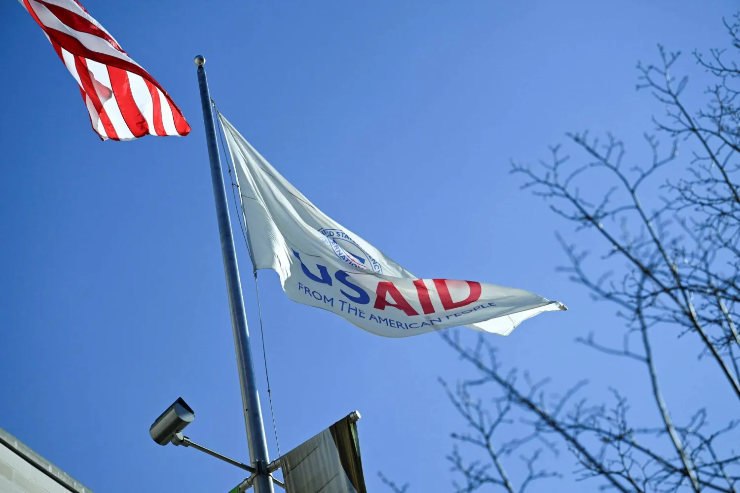 An American flag and USAID flag fly outside the USAID building in Washington, DC, US, February 1, 2025. REUTERS/Annabelle Gordon