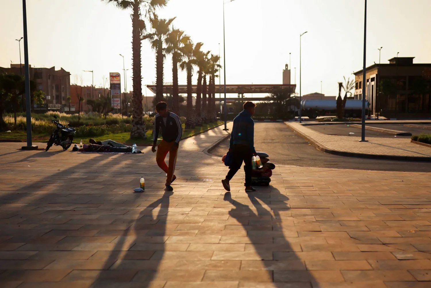 رجال يسيرون على طول الشارع بجوار محطة الحافلات الرئيسية في مراكش (رويترز)