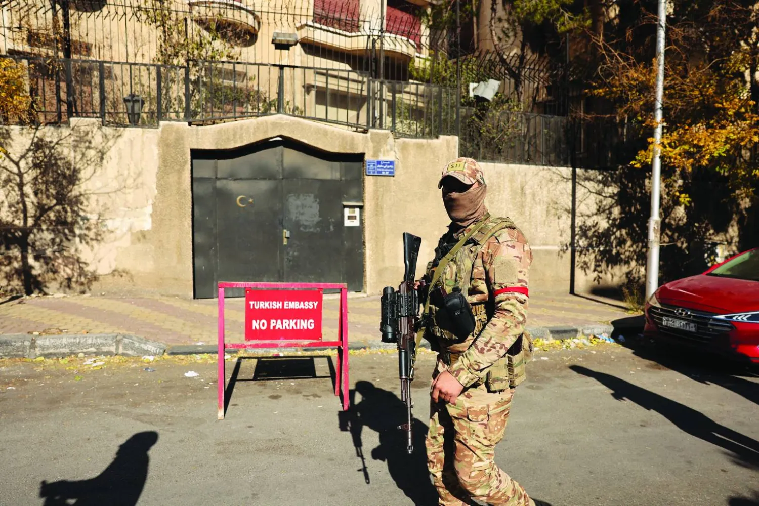 
أحد مقاتلي العمليات العسكرية أمام مقر السفارة التركية في دمشق قبل وقت قليل من إعادة افتتاحها مؤخراً (أ.ف.ب)