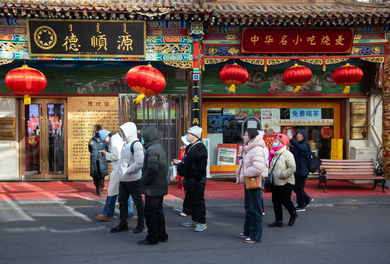 أشخاص يتجولون في أحد شوارع التسوق في بكين (إ.ب.أ)