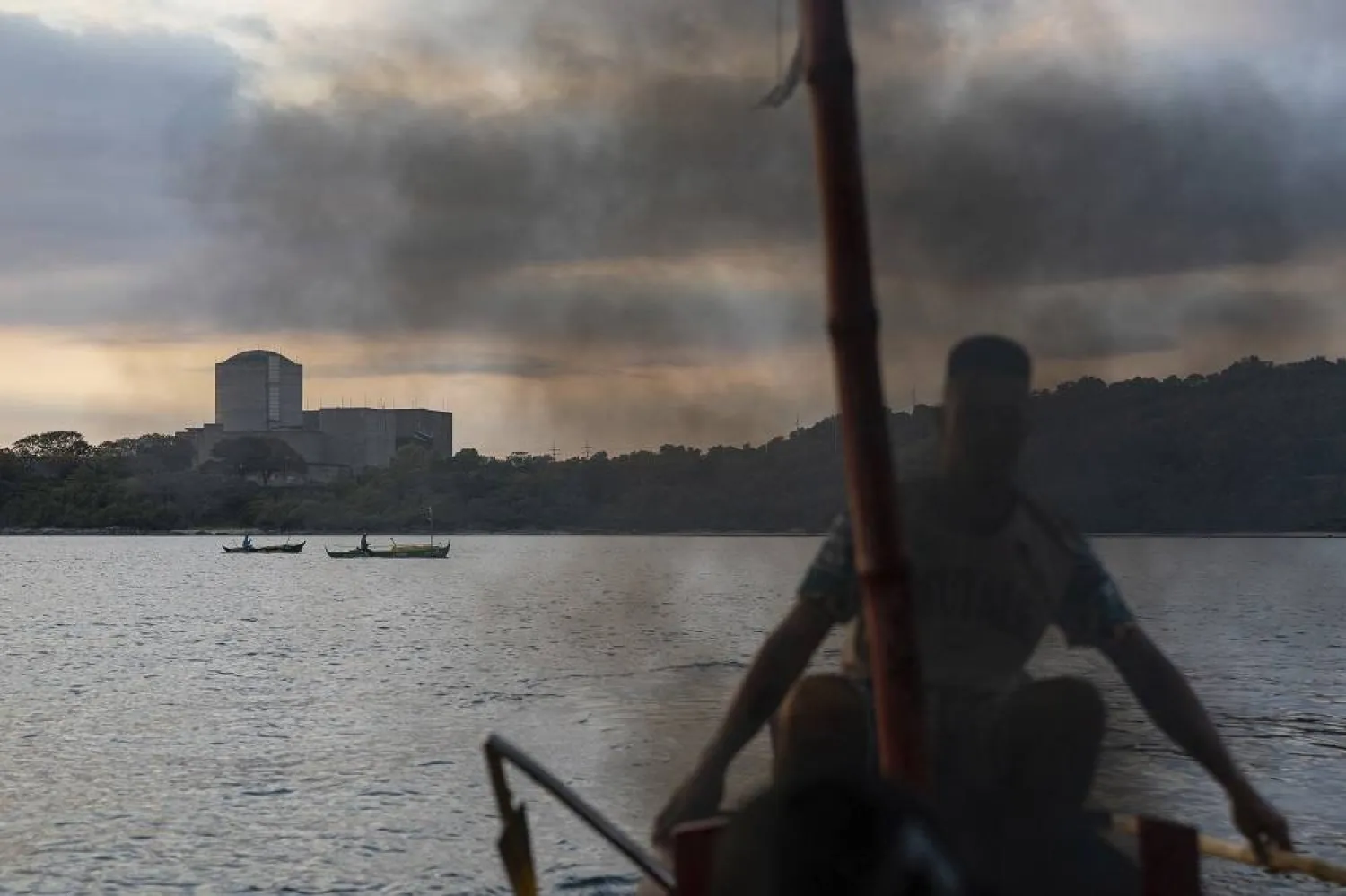 Smoke rises as a fisherman fires up the diesel motor of his boat in front of the Bataan Nuclear Power Plant in the Philippines on Sunday, Jan. 19, 2025. (AP)
