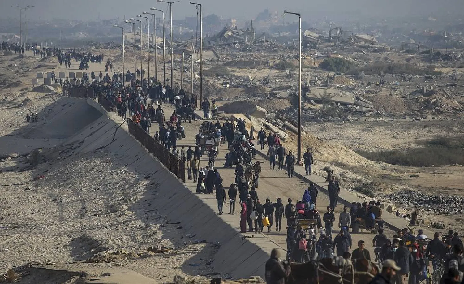 Palestinians make their way among the rubble of destroyed buildings amid a ceasefire between Israel and Hamas, on Al-Rashid road, Gaza City, 02 February 2025. (EPA)