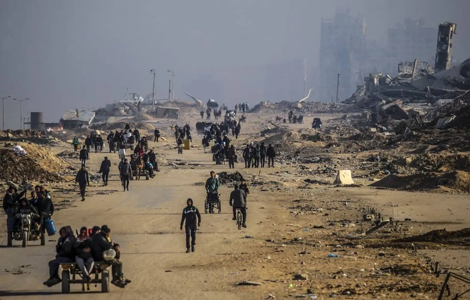 Palestinians make their way among the rubble of destroyed buildings amid a ceasefire between Israel and Hamas, on Al-Rashid road, Gaza City, 02 February 2025. (EPA) 
