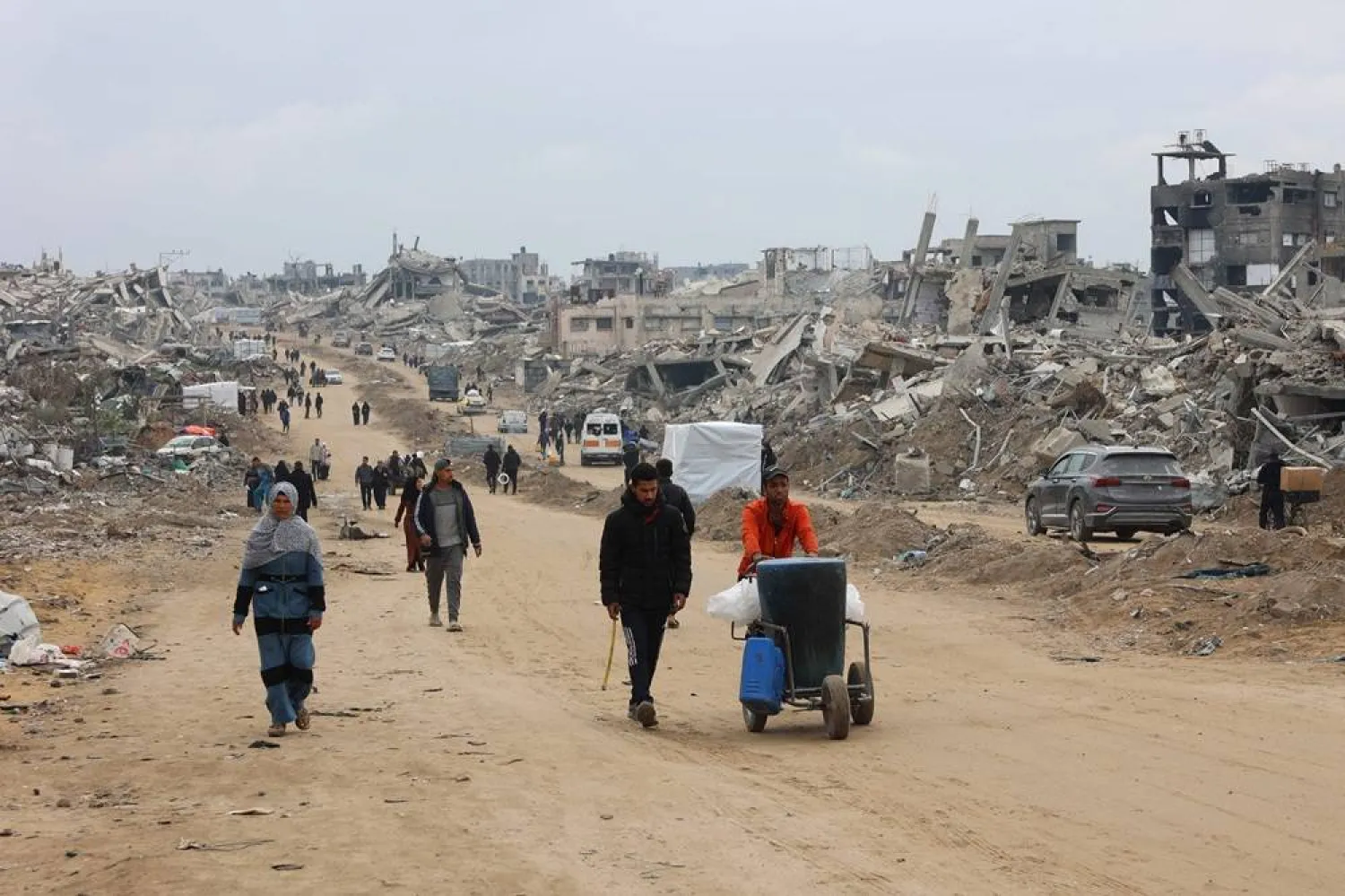 Palestinians walk past collapsed buildings along Saftawi street in Jabalia in the northern Gaza Strip on February 5, 2025 during a ceasefire deal in the war between Israel and Hamas. (AFP)