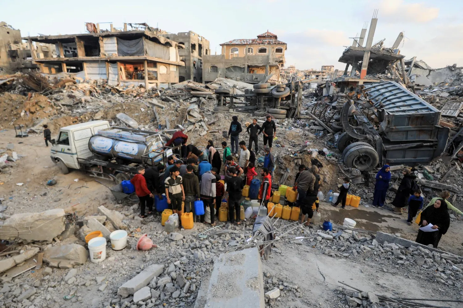 فلسطينيون يملأون حاويات بالمياه وسط وقف إطلاق النار بين إسرائيل وحماس (رويترز)