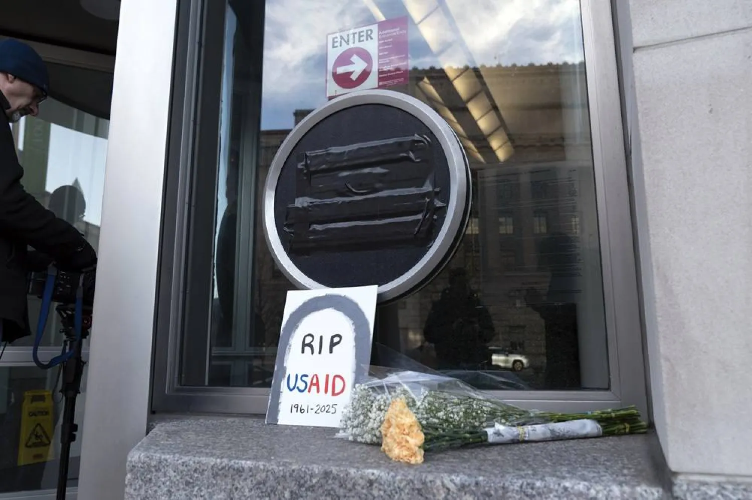  Flowers and a sign are placed outside the headquarters of the US Agency for International Development, or USAID, Friday, Feb. 7, 2025, in Washington. (AP)