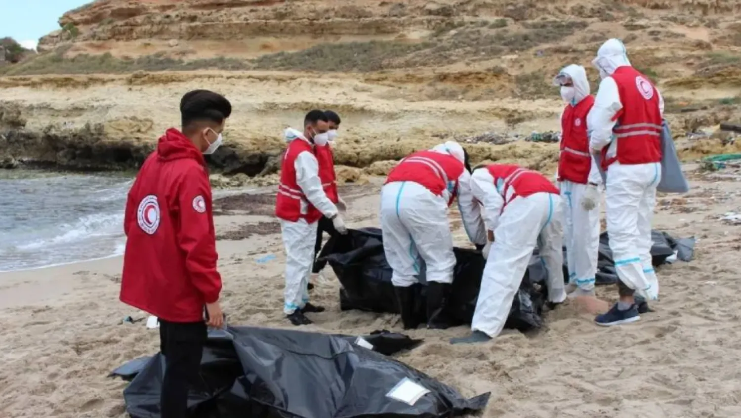 Reuters file photo showing volunteers placing bodies in black plastic bags in Libya
