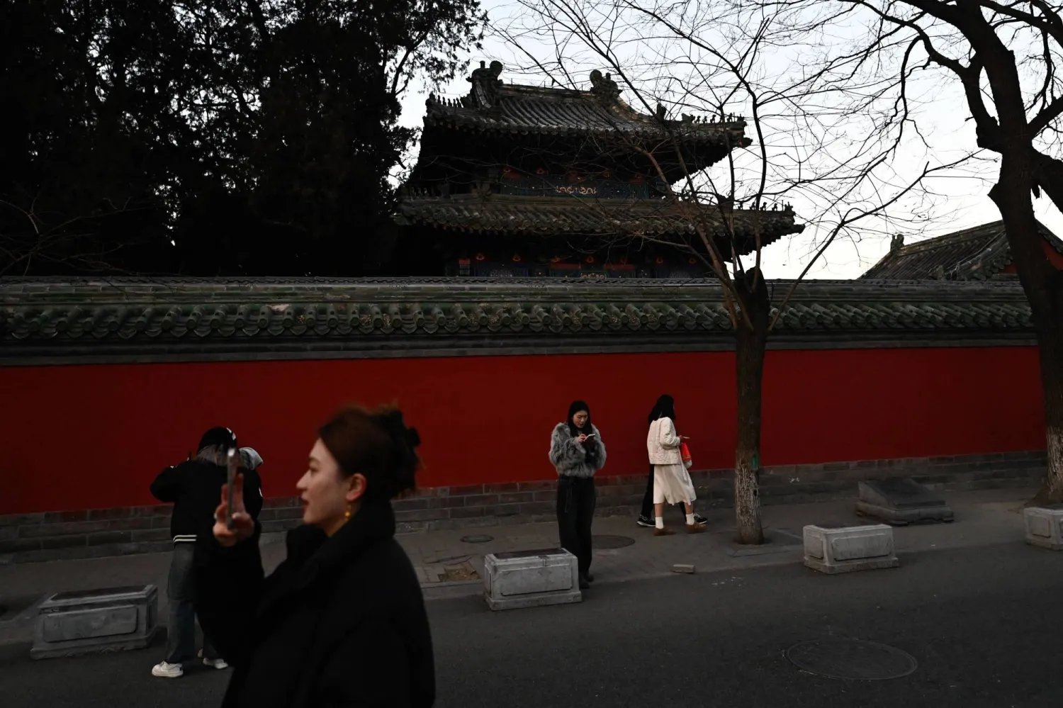 People stroll in Guozijian Hutong alley in Beijing on February 9, 2025. (Photo by Pedro PARDO / AFP)