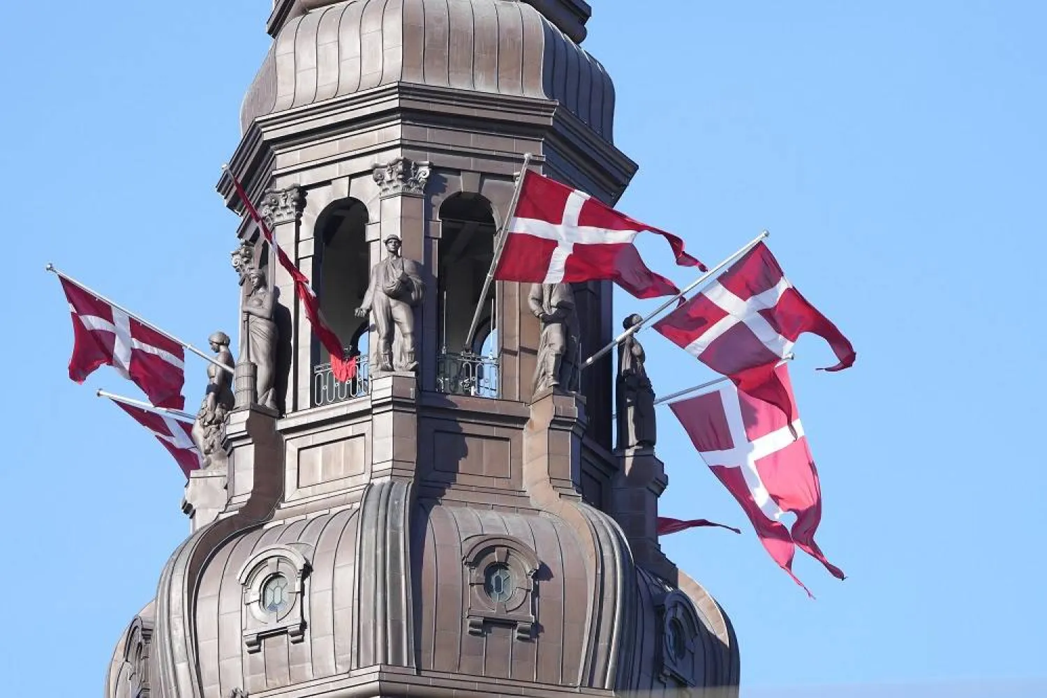 Danish flags are attached to the spire of Christiansborg Castle, the Danish Parliament building in Copenhagen, Denmark, Sept. 5, 2021. (AP)