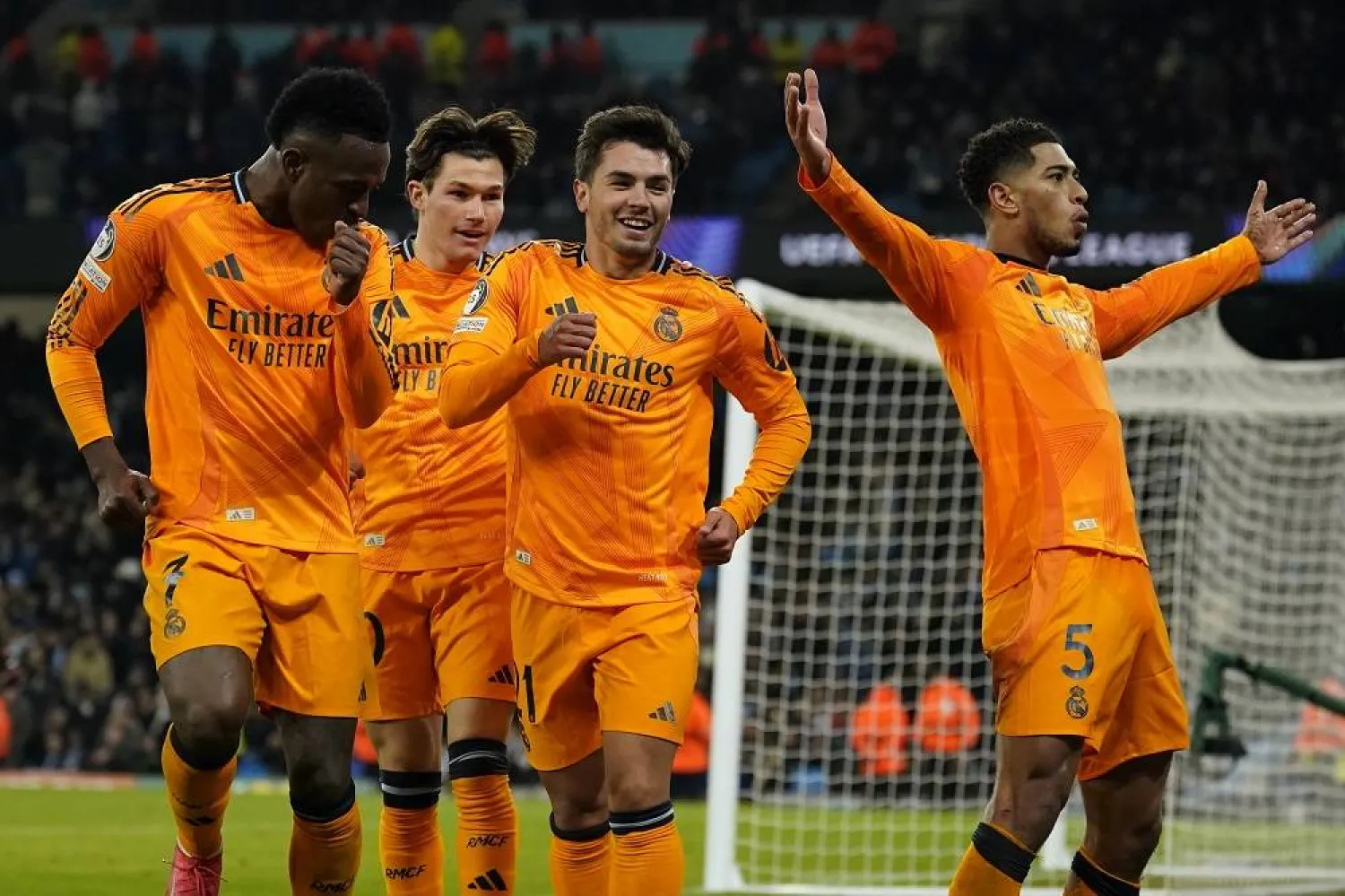 Real Madrid's Jude Bellingham, right, celebrates with teammates after scoring his sides third goal during the Champions League playoff first leg soccer match between Manchester City and Real Madrid at the Etihad Stadium in Manchester, England, Tuesday, Feb. 11, 2025. (AP)