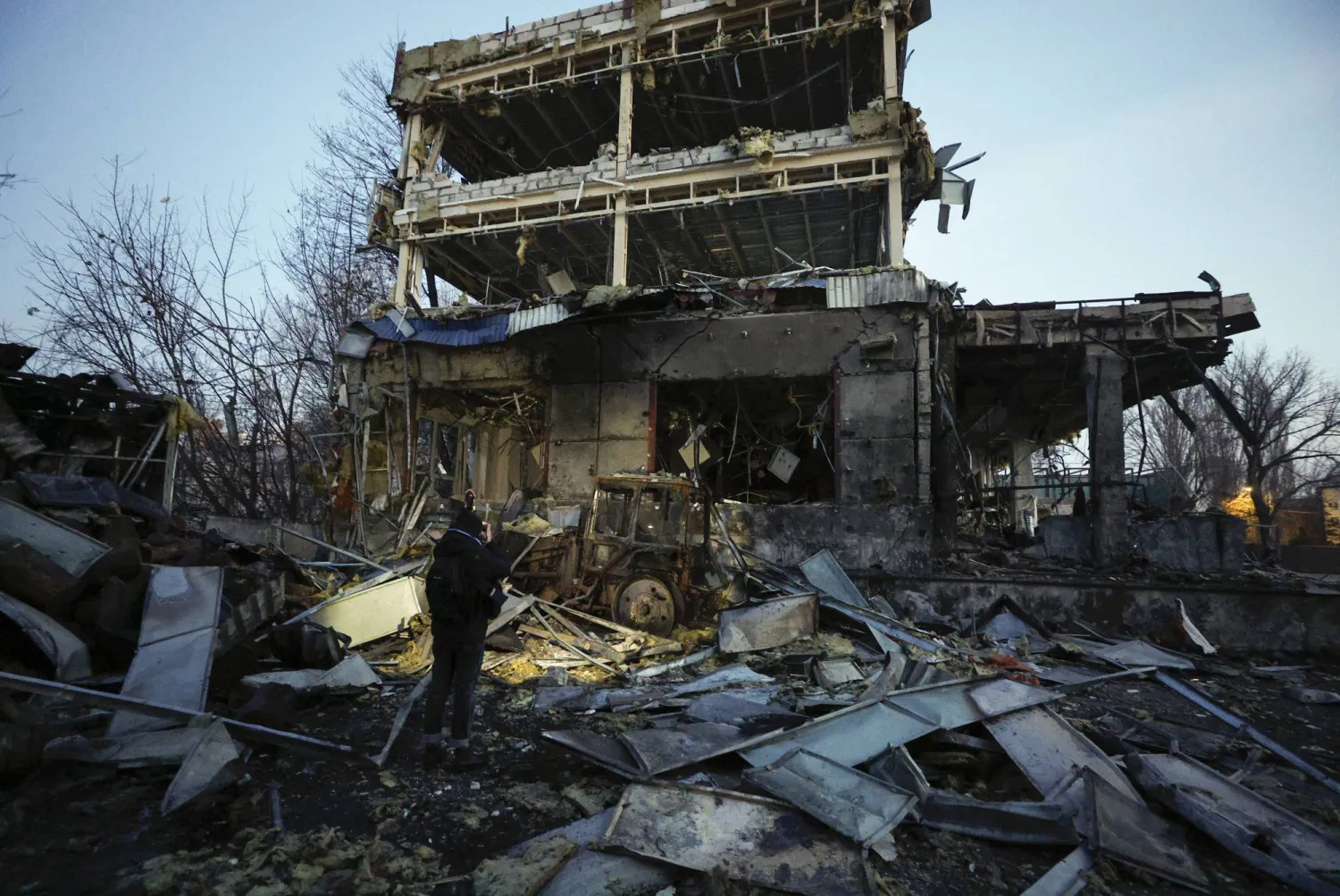 أشخاص ينظرون إلى موقع ضربة صاروخية روسية في كييف (إ.ب.أ)