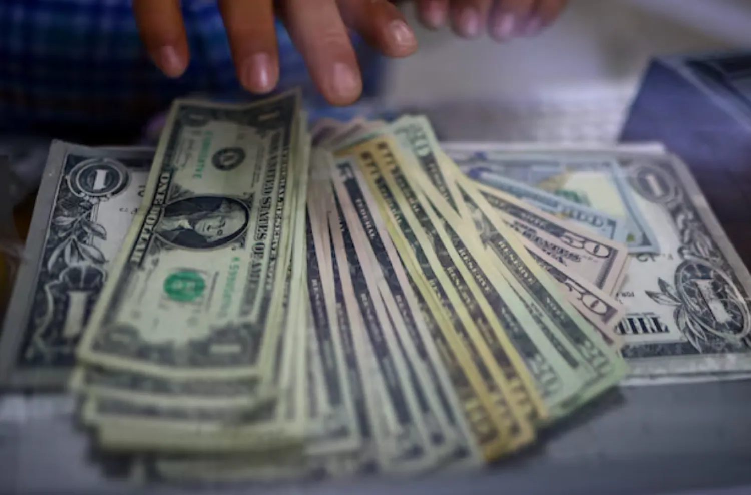 The employee of a currency exchange shop counts US dollar banknotes in Ciudad Juarez, Mexico July 27, 2023. REUTERS/Jose Luis Gonzalez/File Photo 
