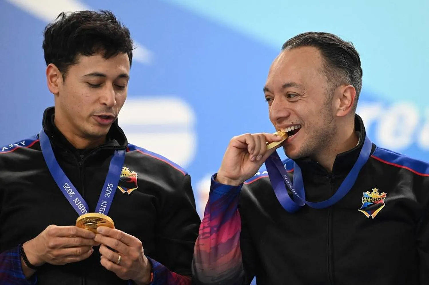 Gold medalist Philippines’ Alan Frei (R) and Enrico Pfister react during the awards ceremony of the men’s team curling event during the Harbin 2025 Asian Winter Games in Harbin, northeast China's Heilongjiang province on February 14, 2025. (AFP) 