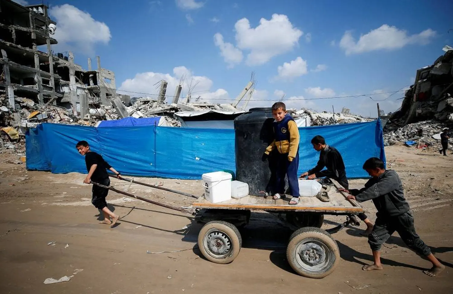 Palestinian children ride a wagon on a street among the rubble of buildings destroyed during the Israeli offensive, amid a ceasefire between Israel and Hamas, at Jabalia refugee camp, northern Gaza Strip, February 17, 2025. (Reuters) 