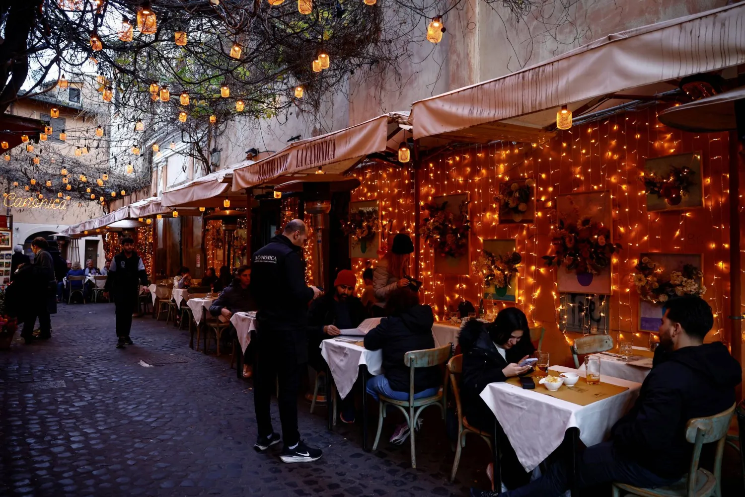 أشخاص يجلسون في مطعم بمنطقة تراستيفيري بروما (رويترز)