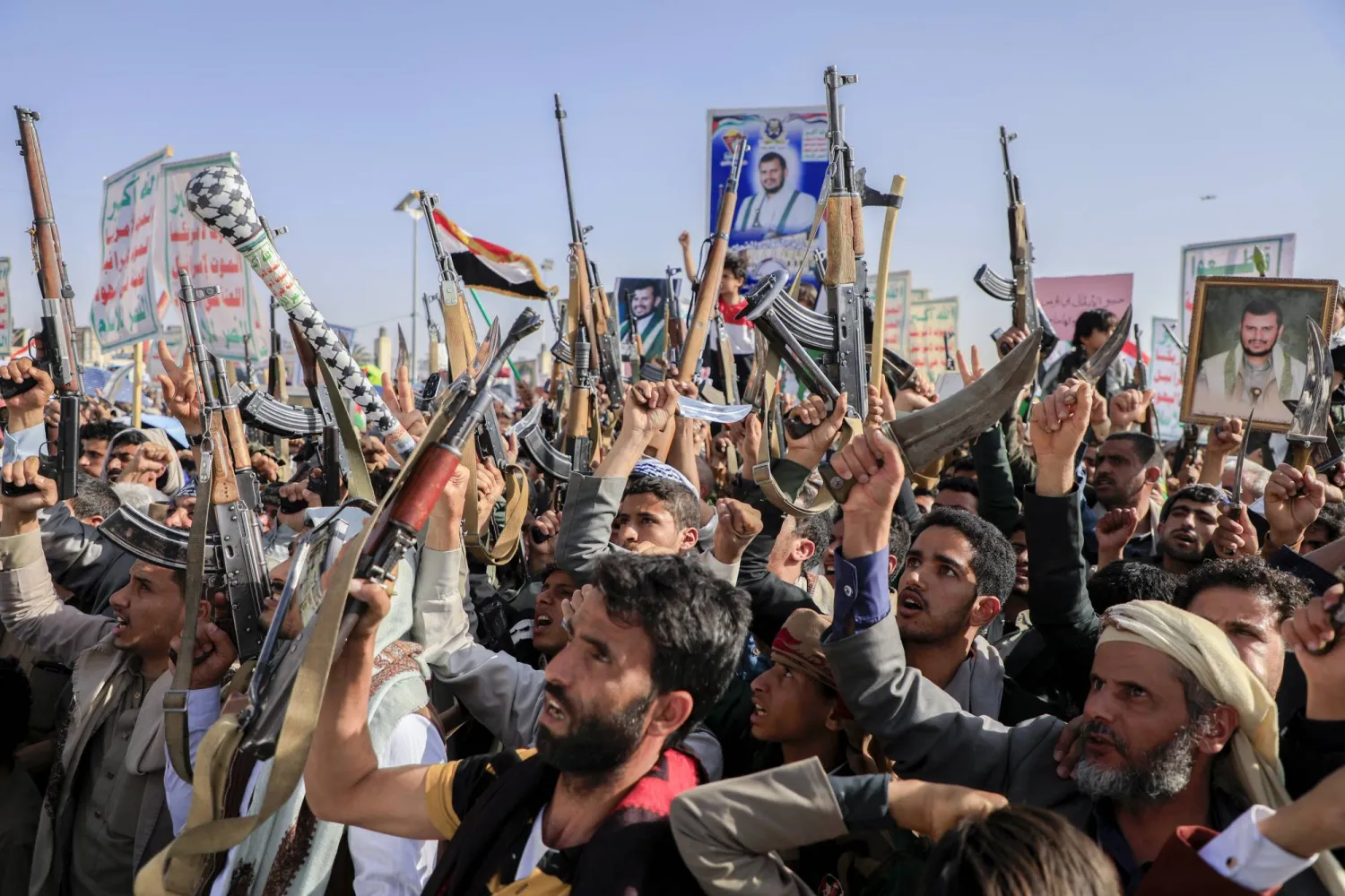 Houthi supporters raise weapons as they shout slogans during an anti-US and anti-Israel rally in Sanaa, Yemen, Friday, Feb. 14, 2025. (AP Photo/Osamah Abdulrahman)