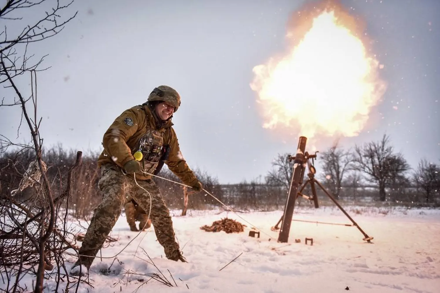 A Ukrainian serviceman of the 24 Separate Mechanized Brigade named after King Danylo fires a mortar towards Russian positions, at an undisclosed location in the Donetsk region, eastern Ukraine, 17 February 2023. (EPA) 