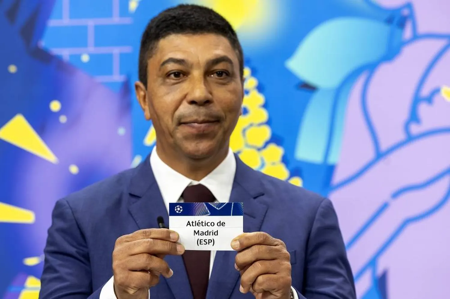 Former Bayern Munich striker Giovane Elber shows the ticket of Atletico Madrid during the UEFA Champions League round of 16, quarter-final and semi-final draws, at the UEFA headquarters in Nyon, Switzerland, 21 February 2025. (EPA) 