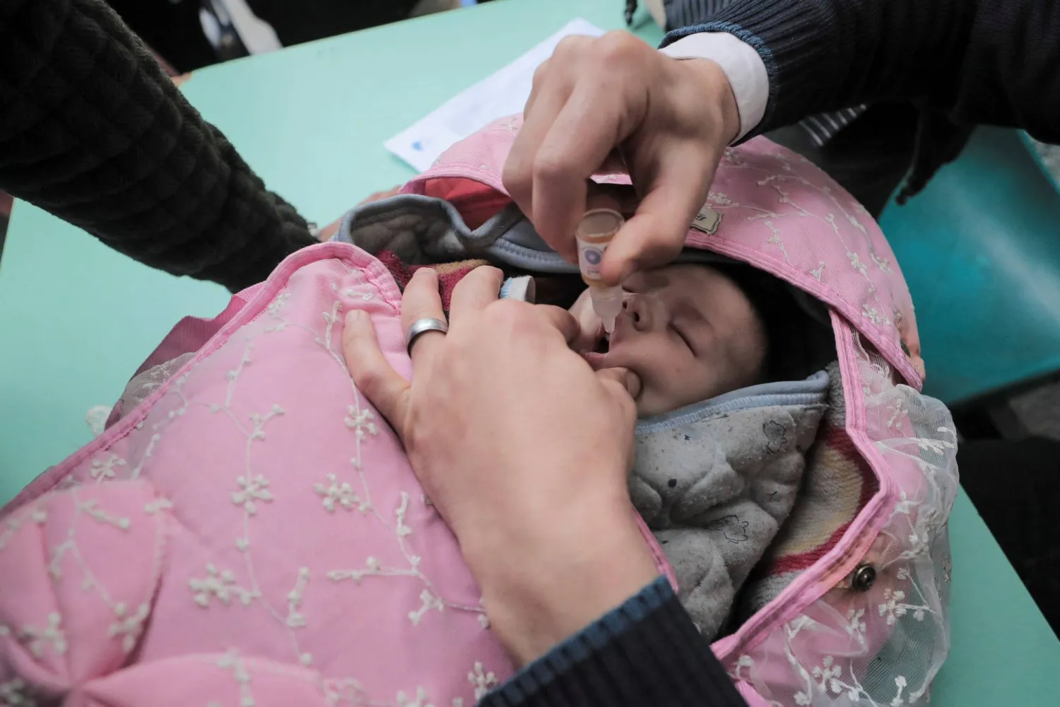 طفل فلسطيني يتلقى لقاحاً ضد شلل الأطفال وسط وقف إطلاق النار في غزة (رويترز)