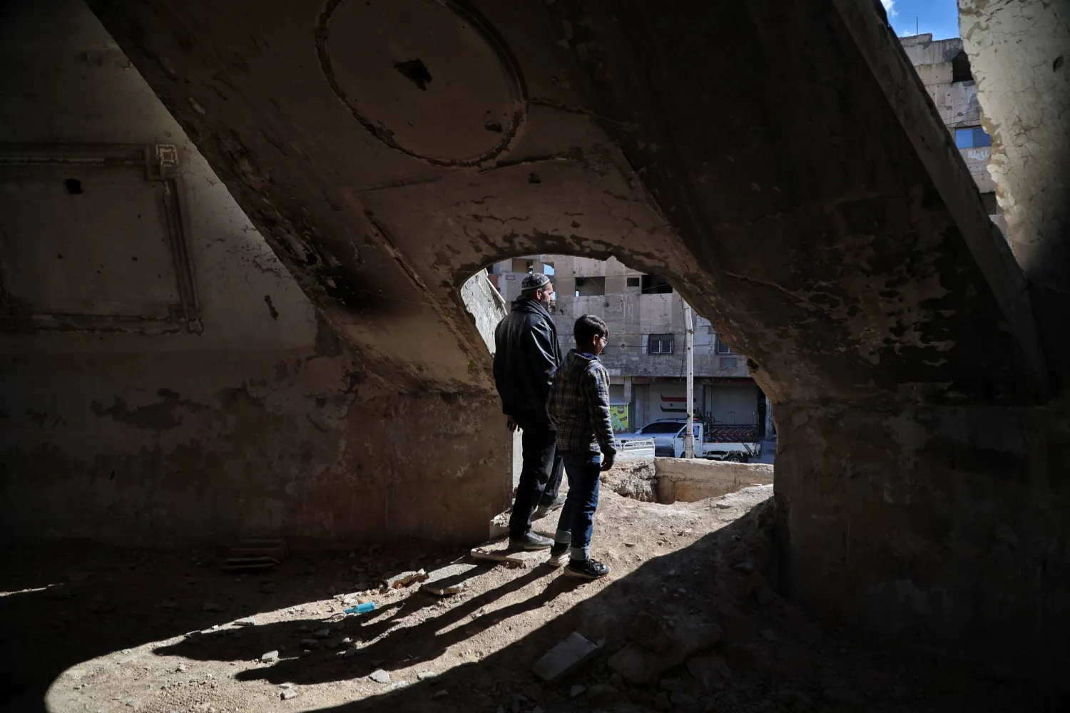 A Syrian family who once sought refuge in tunnels during the bombings by al-Assad's regime stands at the entrance of a tunnel beneath the city in Douma, the countryside of Damascus, Syria, 21 February 2025. EPA/BILAL AL HAMMOUD