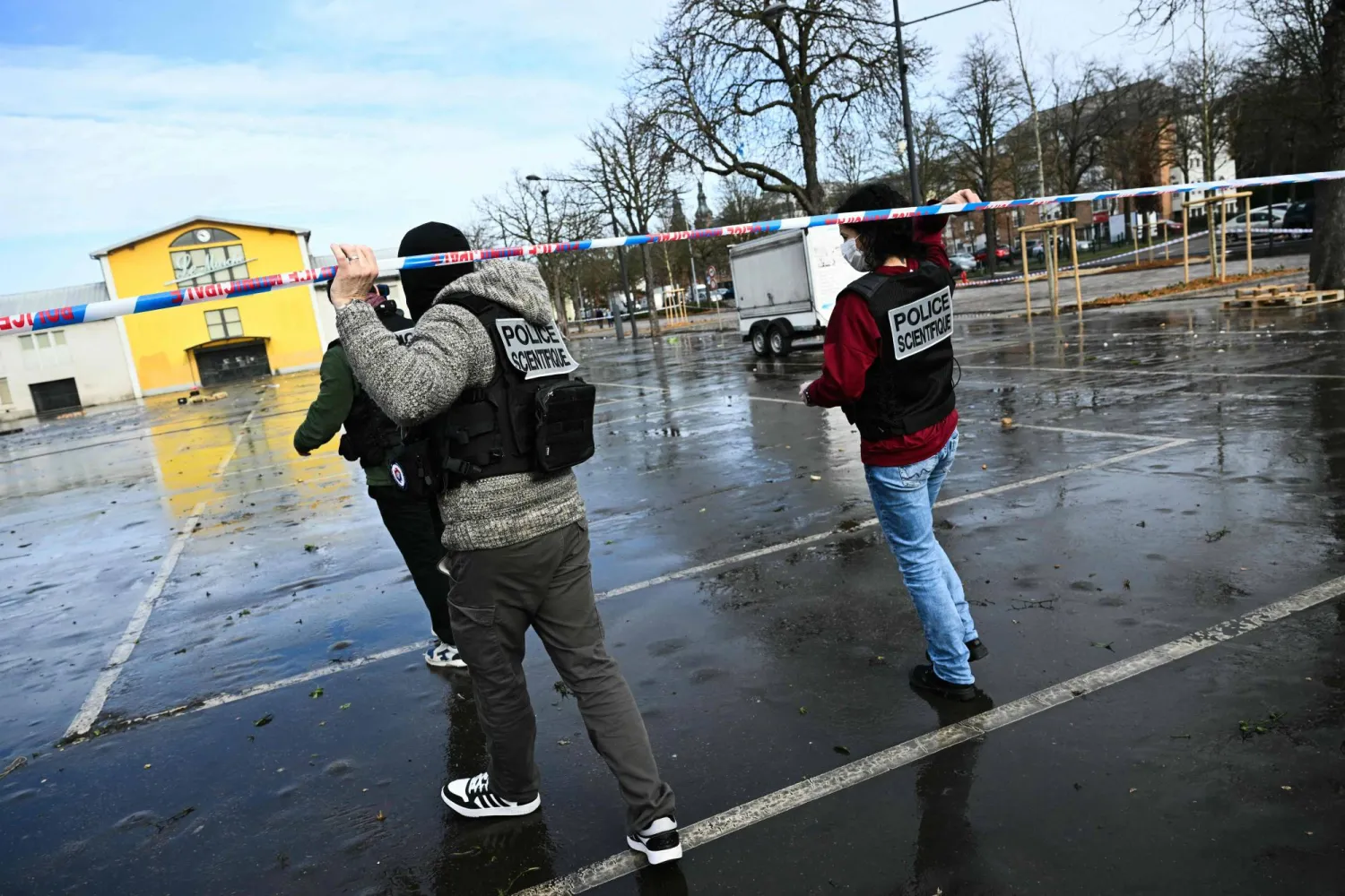 French forensic police walk under police caution tape as they arrive to collect evidence at the site of a bladed weapon attack in Mulhouse, eastern France on February 23, 2025. (Photo by SEBASTIEN BOZON / AFP)