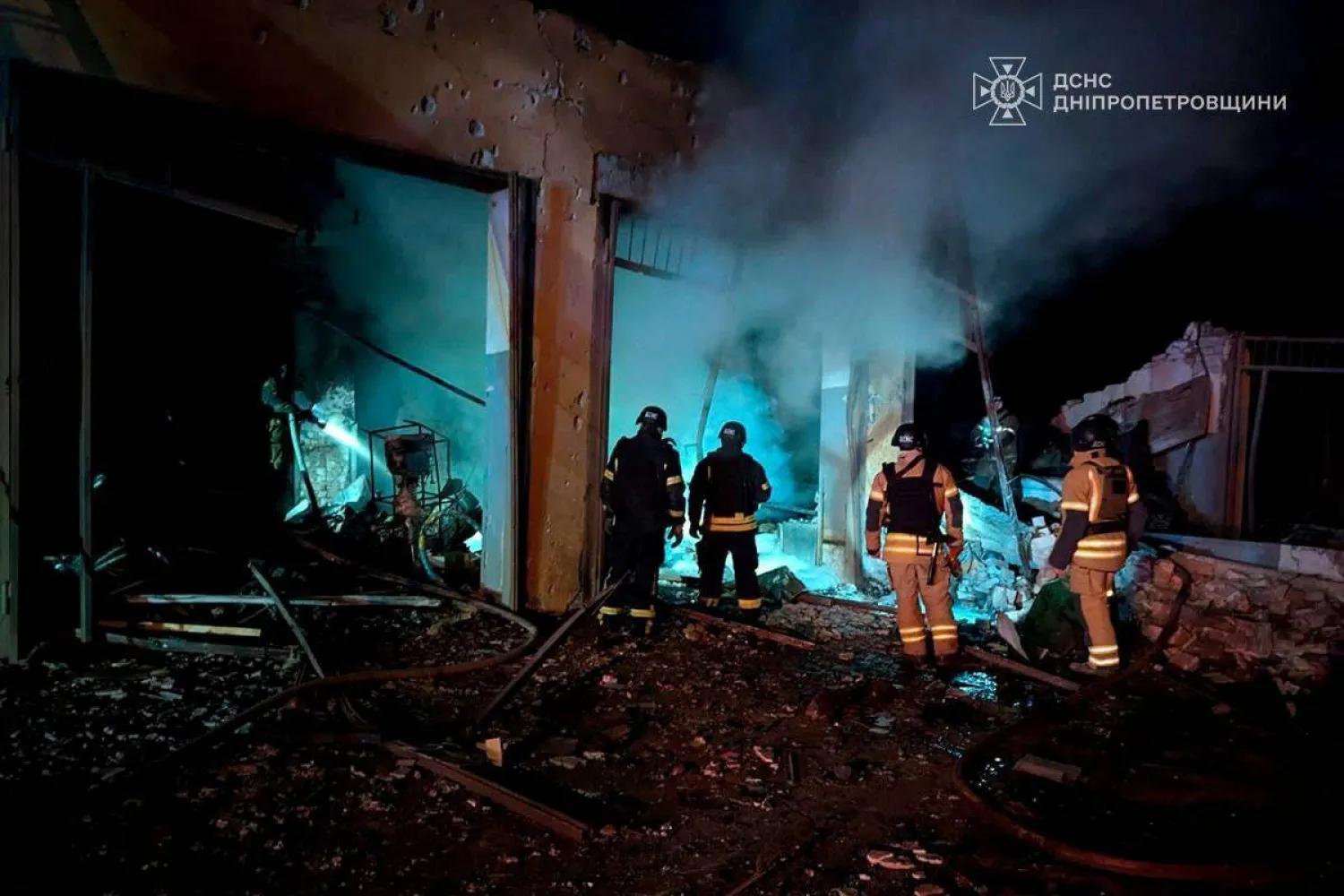 عمال الإنقاذ يعملون في موقع ضربة صاروخية روسية على كريفي ريه في أوكرانيا (رويترز)