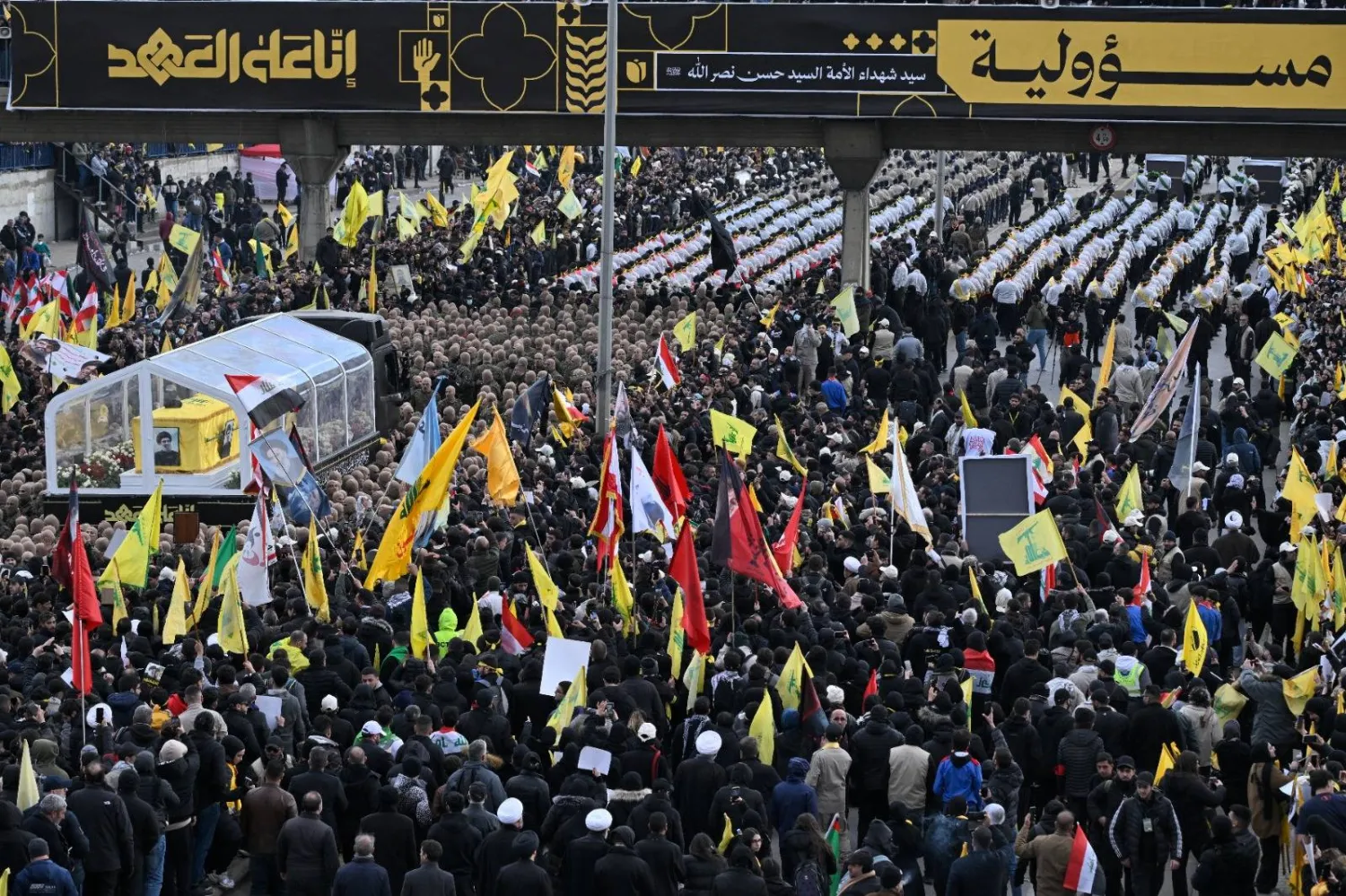 نعشا نصر الله وصفي الدين على شاحنة في طريقهما إلى موقع الدفع قرب طريق المطار (الشرق الأوسط)