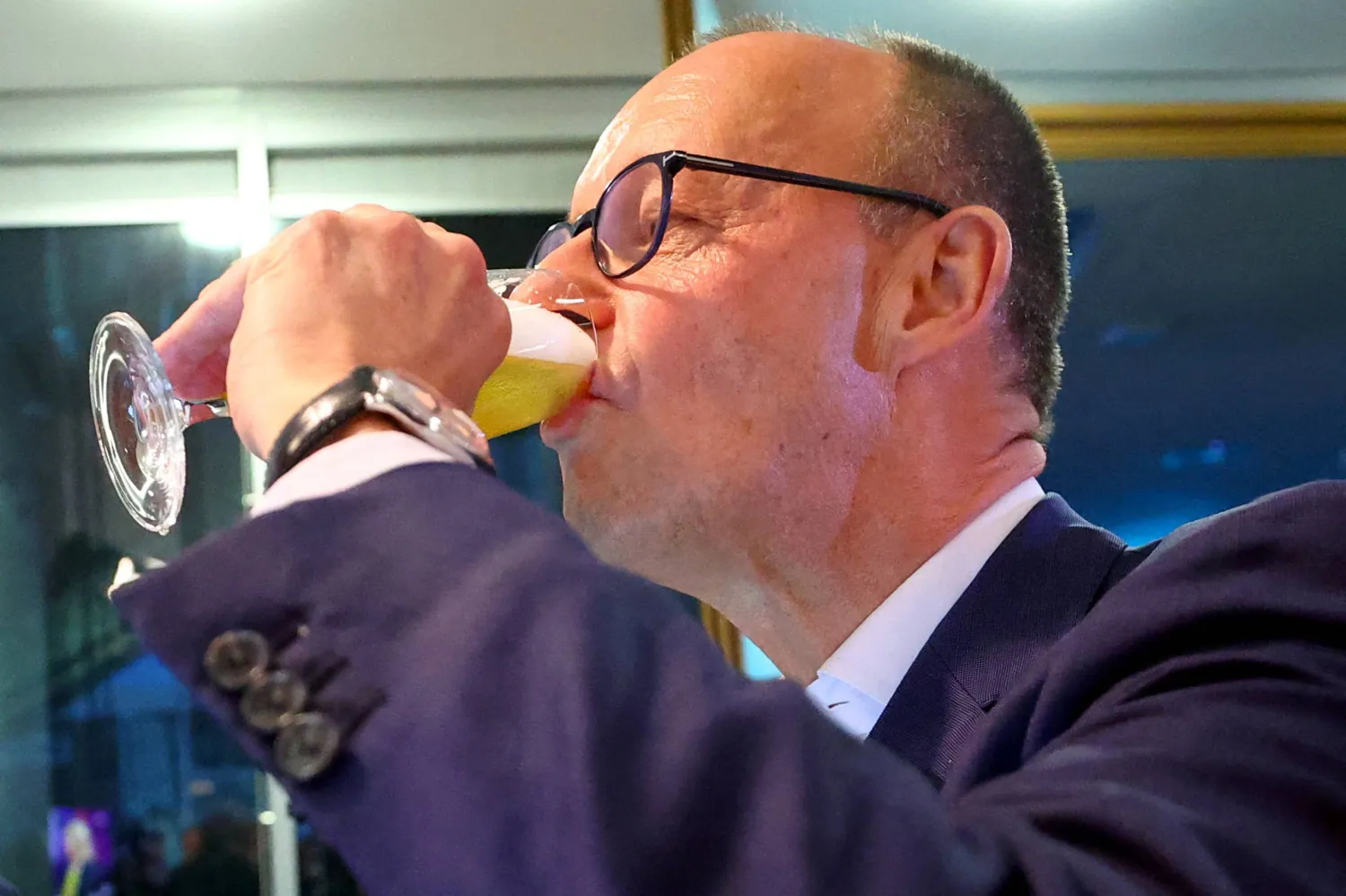 الزعيم الألماني المحافظ الفائز في الانتخابات الألمانية فريدريش ميرتس يشرب نخب الانتصار في برلين (رويترز)