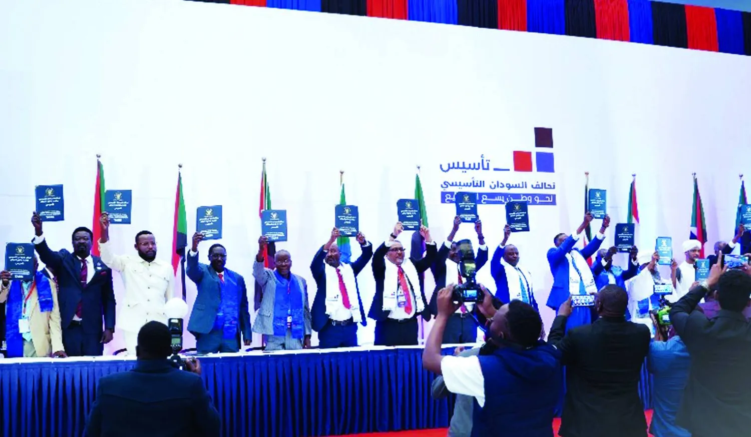 
ممثلو الأحزاب السودانية وقادة جماعات مسلحة يلوحون بميثاق الحكومة المزمع تشكيلها، بعد توقيعه الأحد في نيروبي (الشرق الأوسط)
