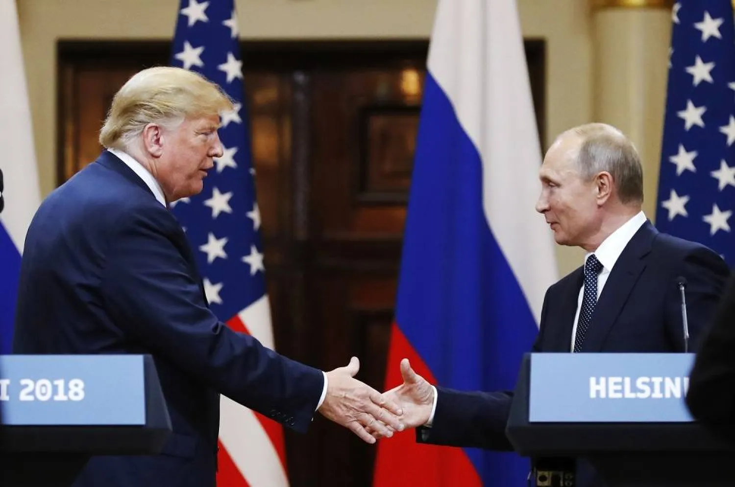 In this file photo taken on Monday, July 16, 2018, US President Donald Trump shakes hand with Russian President Vladimir Putin at the end of the press conference after their meeting at the Presidential Palace in Helsinki, Finland. (AP)
