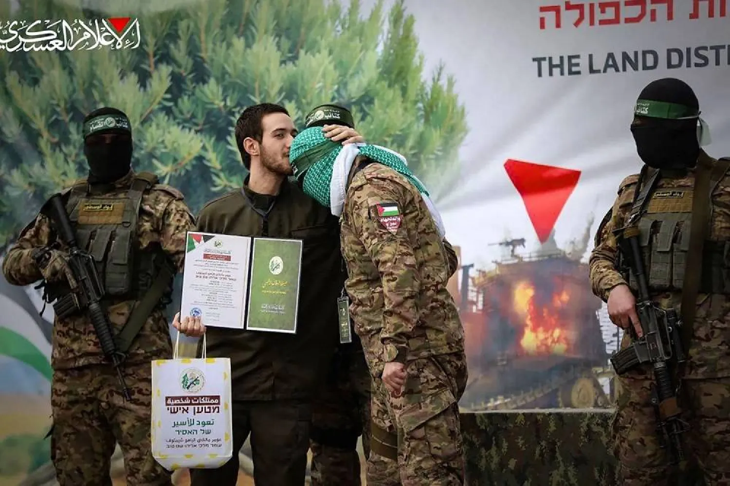 Former Israeli prisoner Omer Shem Tov kisses the head of a member of Hamas’ Al-Qassam Brigades during last week’s swap. (Photo released by Hamas / AFP) 