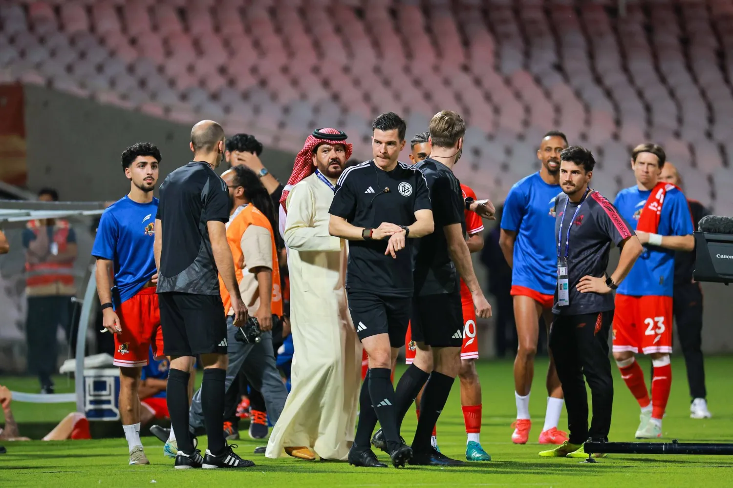 حكم المباراة وسط مسؤولي نادي الوحدة الذين يطالبون باعتبار النصر منسحباً (محمد المانع)