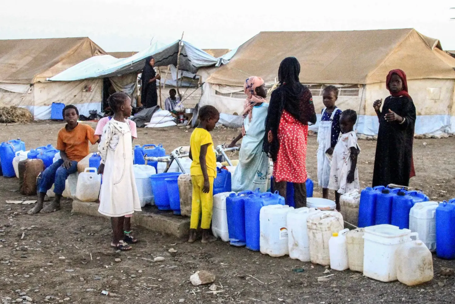 Women and children wait to fill their jerrycans with water at the Huri camp for people displaced by the ongoing conflict in Sudan, south of Gedaref in eastern Sudan, on March 29, 2024 during the Muslim holy month of Ramadan. (Photo by Ebrahim Hamid / AFP)
