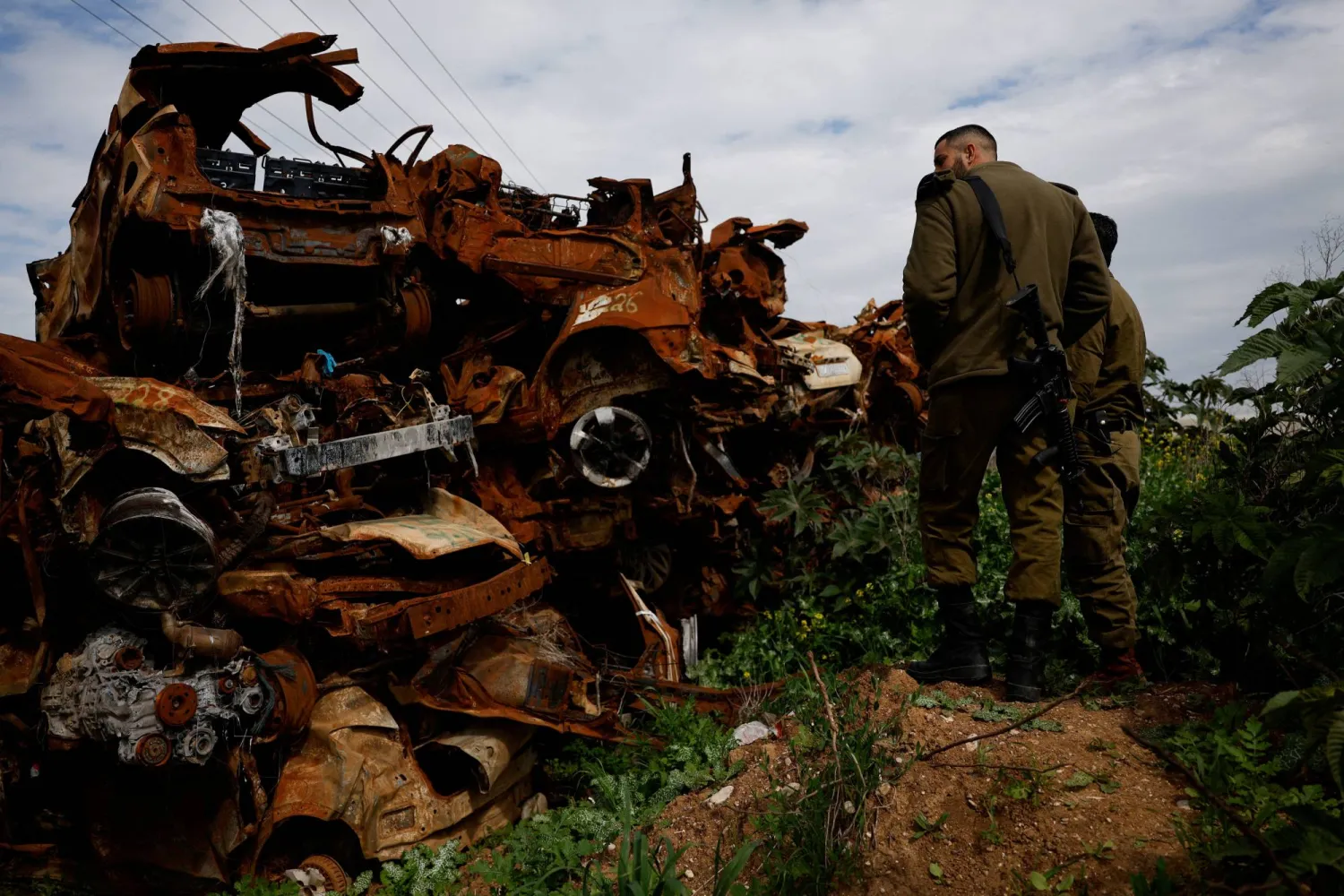 جنديان إسرائيليان يزوران موقعاً وُضعت فيه العربات التي تضررت خلال هجوم «حماس» في 7 أكتوبر 2023 (رويترز)