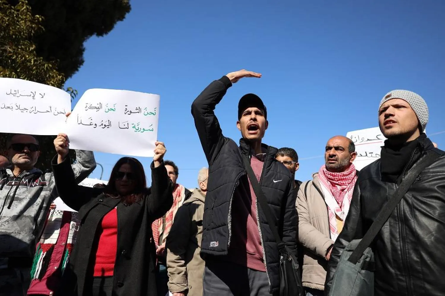 Syrians hold placards and shout slogans during a protest in front of the UN headquarters in Damascus, Syria, 25 February 2025. (EPA) 