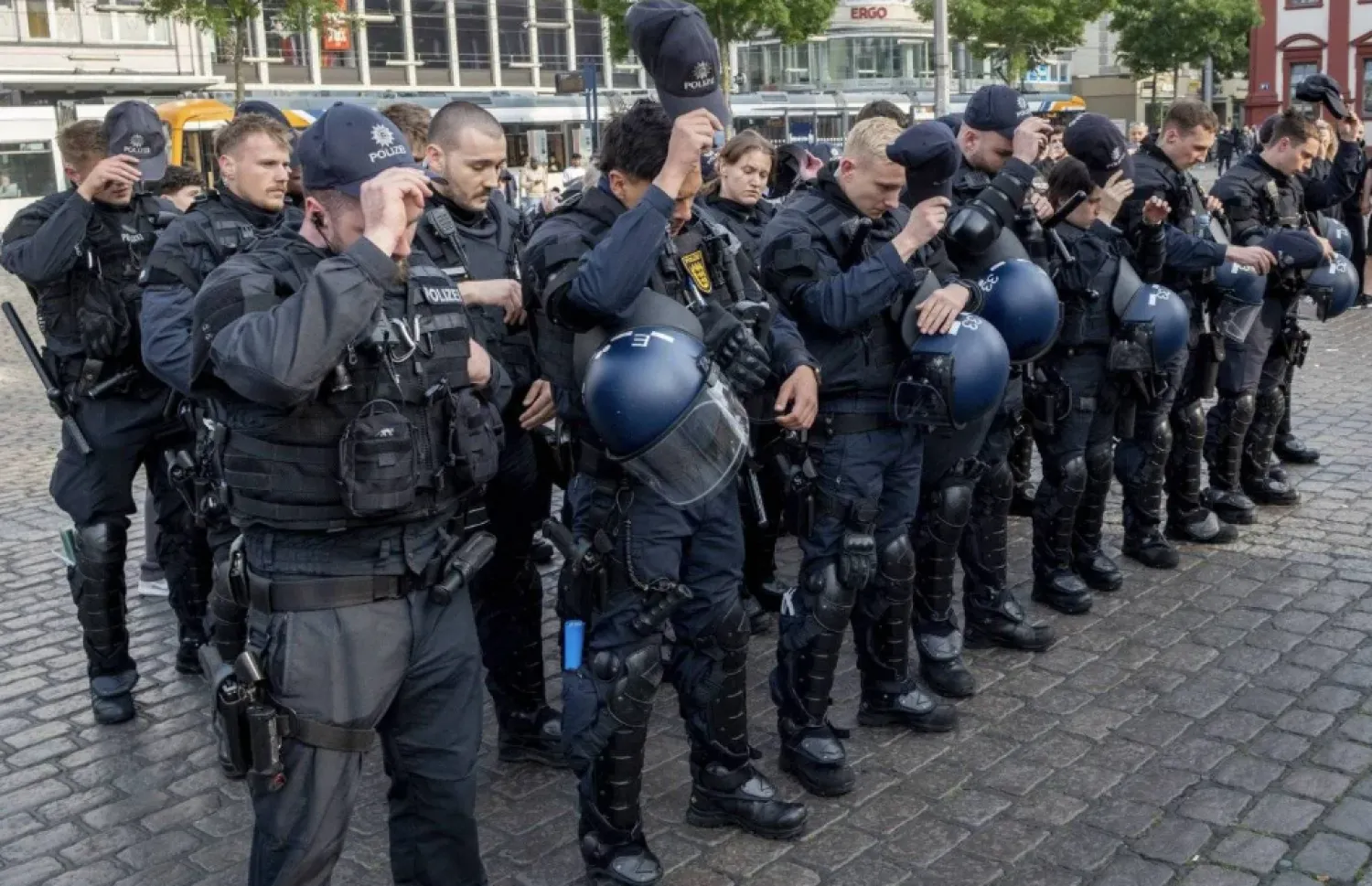 German police officers commemorate a colleague in Mannheim Germany, after learning that a police officer, who was stabbed two days ago there, has died on June 2, 2024. (AP)
