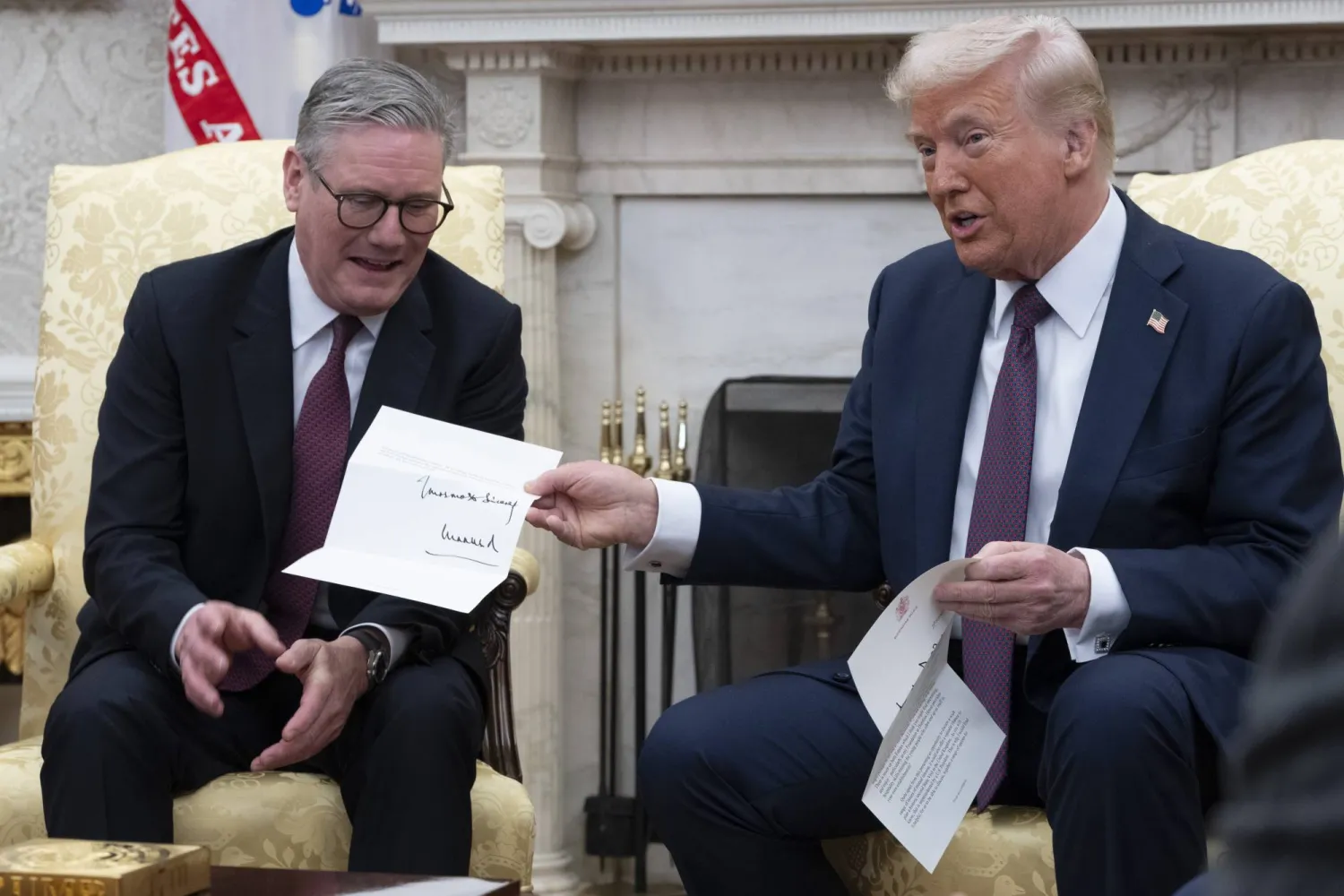 الرئيس الأميركي دونالد ترمب (يمين) ورئيس الوزراء البريطاني كير ستارمر يعرضان رسالة من الملك البريطاني تشارلز (إ.ب.أ)